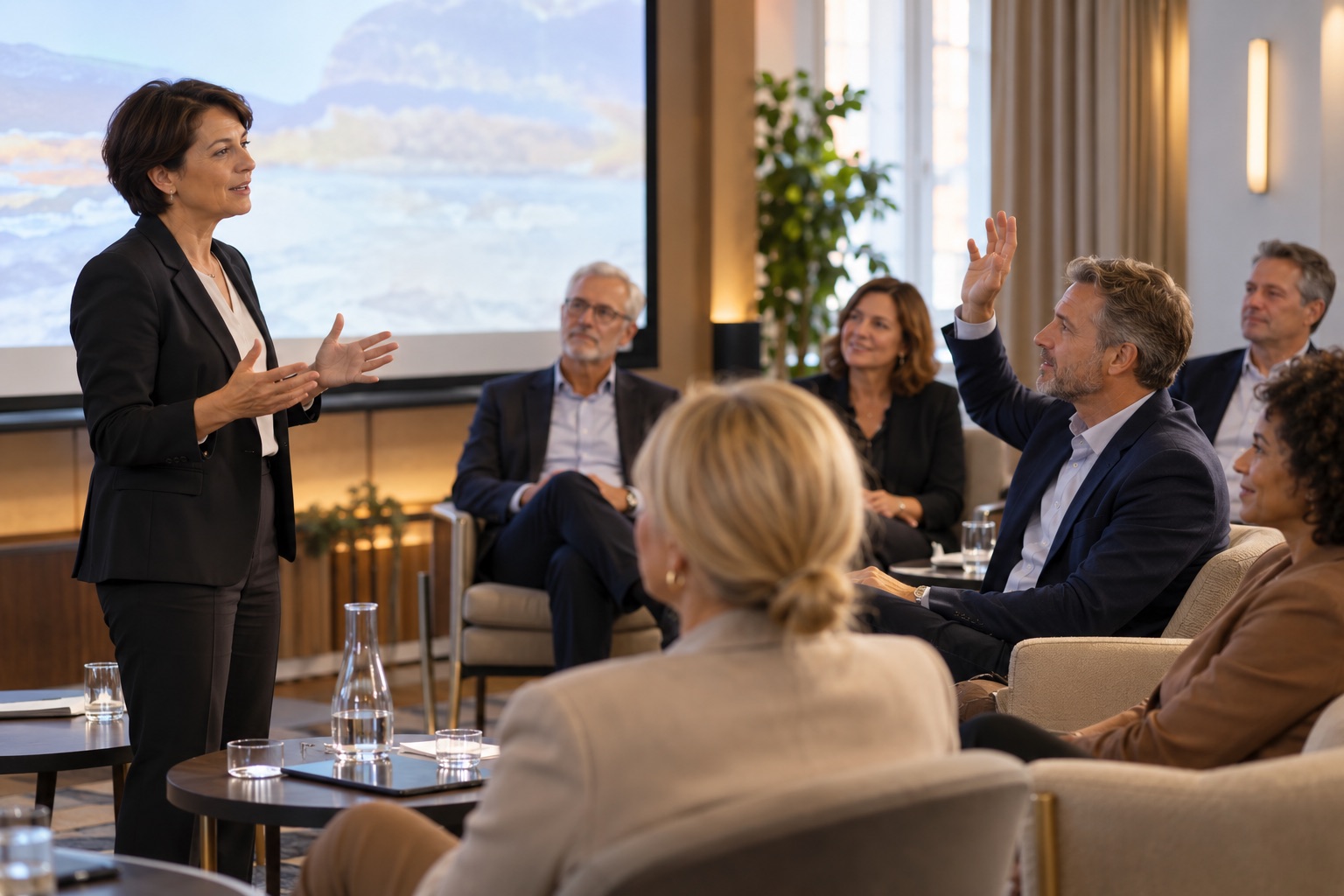 Illustratieve werksituatie: Een vrouwelijke spreker gaat tijdens een masterclass in gesprek met deelnemers.